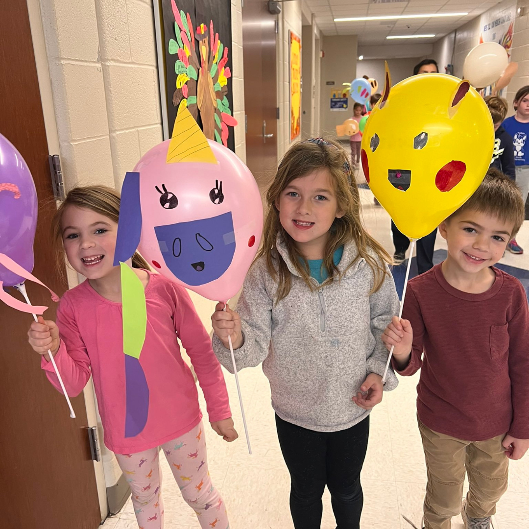 Kindergarten students hold decorated balloons they made